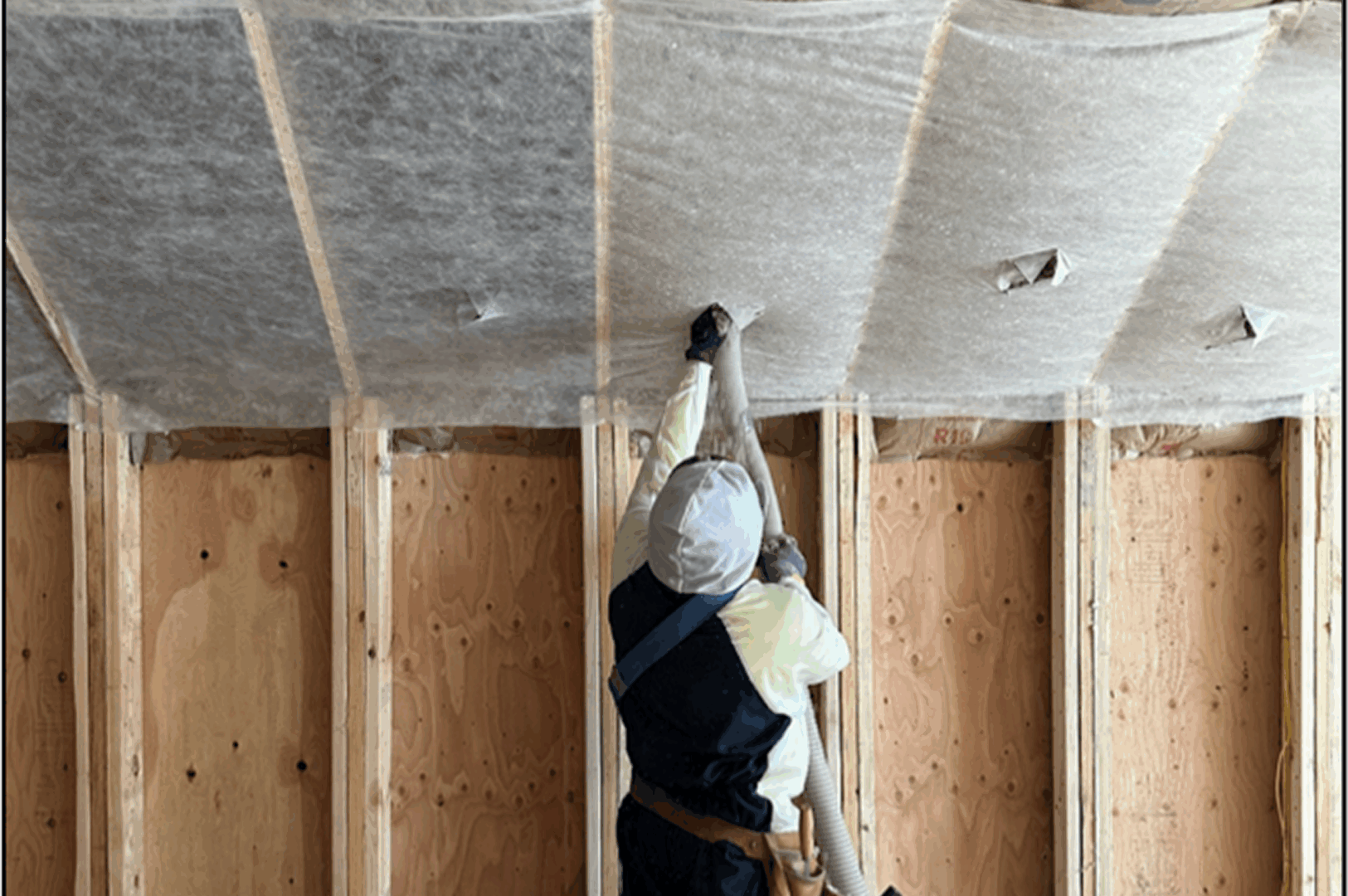 Insulation being placed by construction worker
