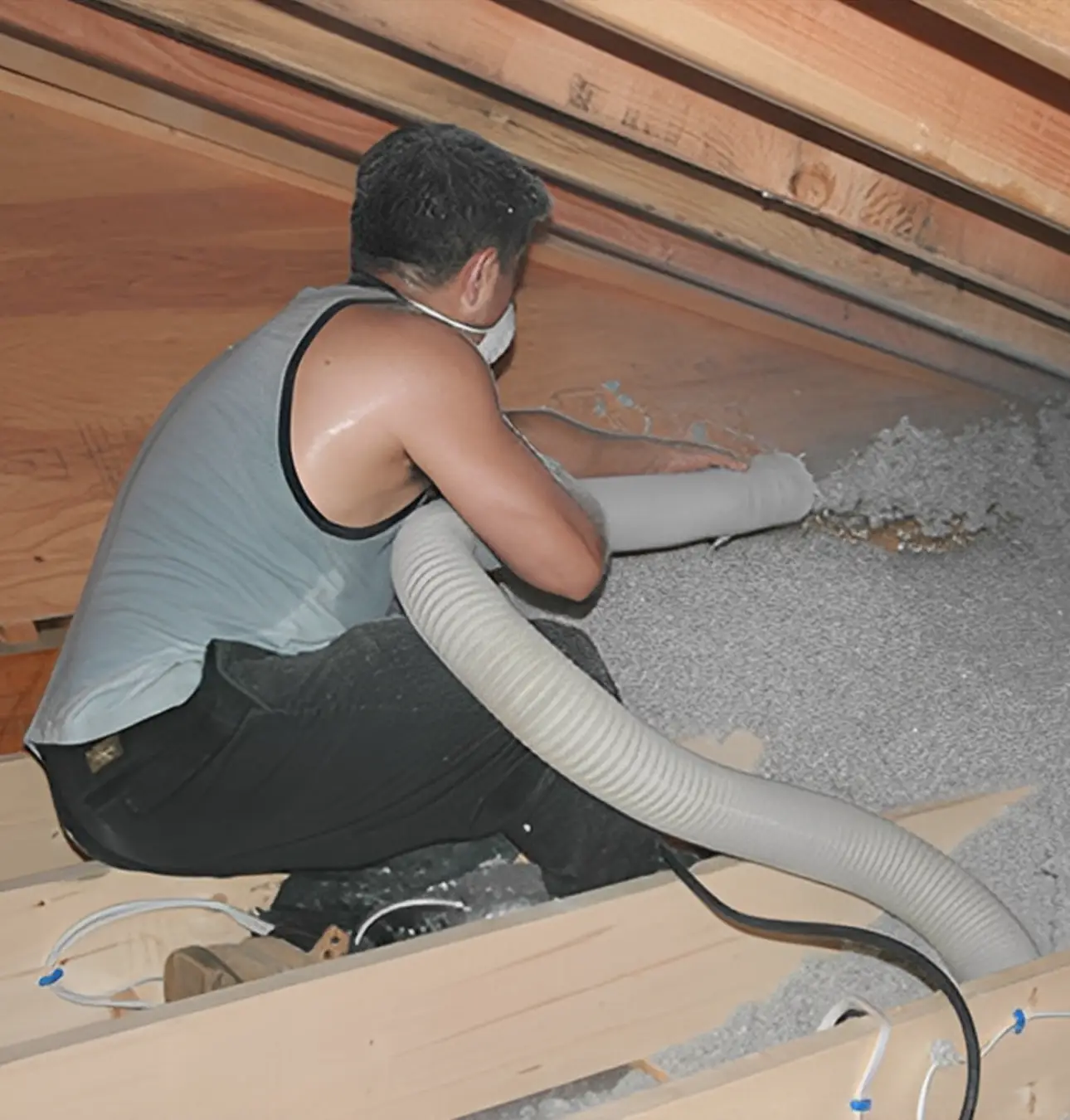 Man applying insulation in attic